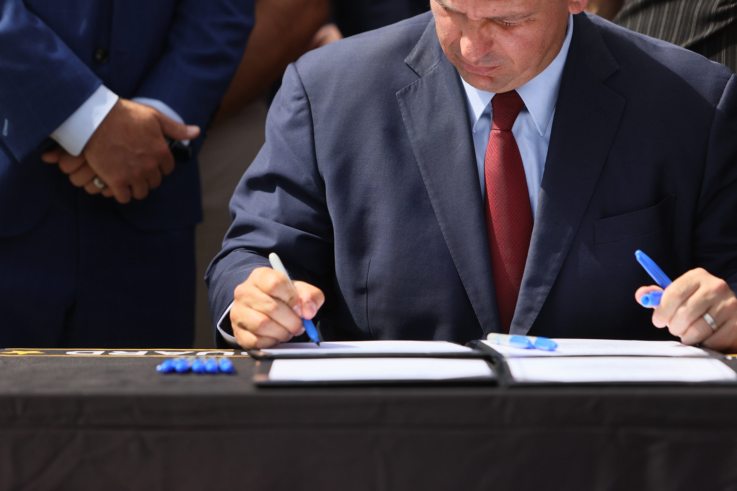 Florida Gov. Ron DeSantis signs two bills surrounded by officials on June 7 in Miami, Florida. (Joe Raedle/Getty Images)