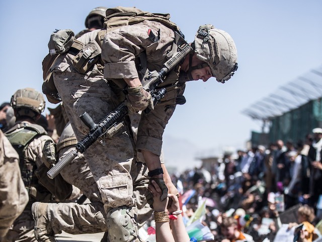 Biden's Order to Get 'F-cking Asses in Seats' Contributed to August 26 Afghanistan Attack that Killed 13 Americans 2 A Marine with Special Purpose Marine Air-Ground Task Force-Crisis Response-Central Command (SPMAGTF-CR-CC) lifts an evacuee during an evacuation at Hamid Karzai International Airport, Kabul, Afghanistan, Aug. 26. U.S. service members are assisting the Department of State with an orderly drawdown of designated personnel in Afghanistan. (U.S. Marine Corps photo by Sgt. Samuel Ruiz).