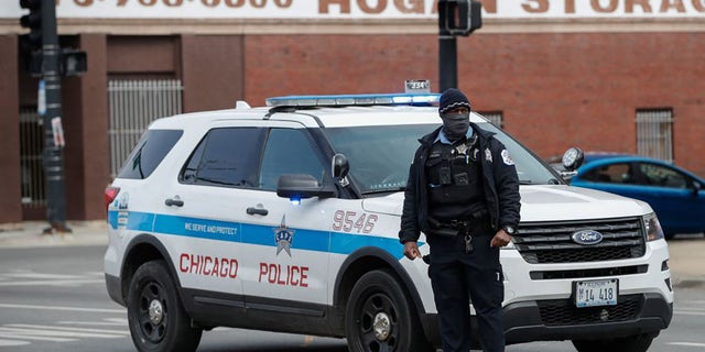 Illinois to End Cash Bail 2 A Chicago police officer monitors the scene after a shooting on March 14, 2021.